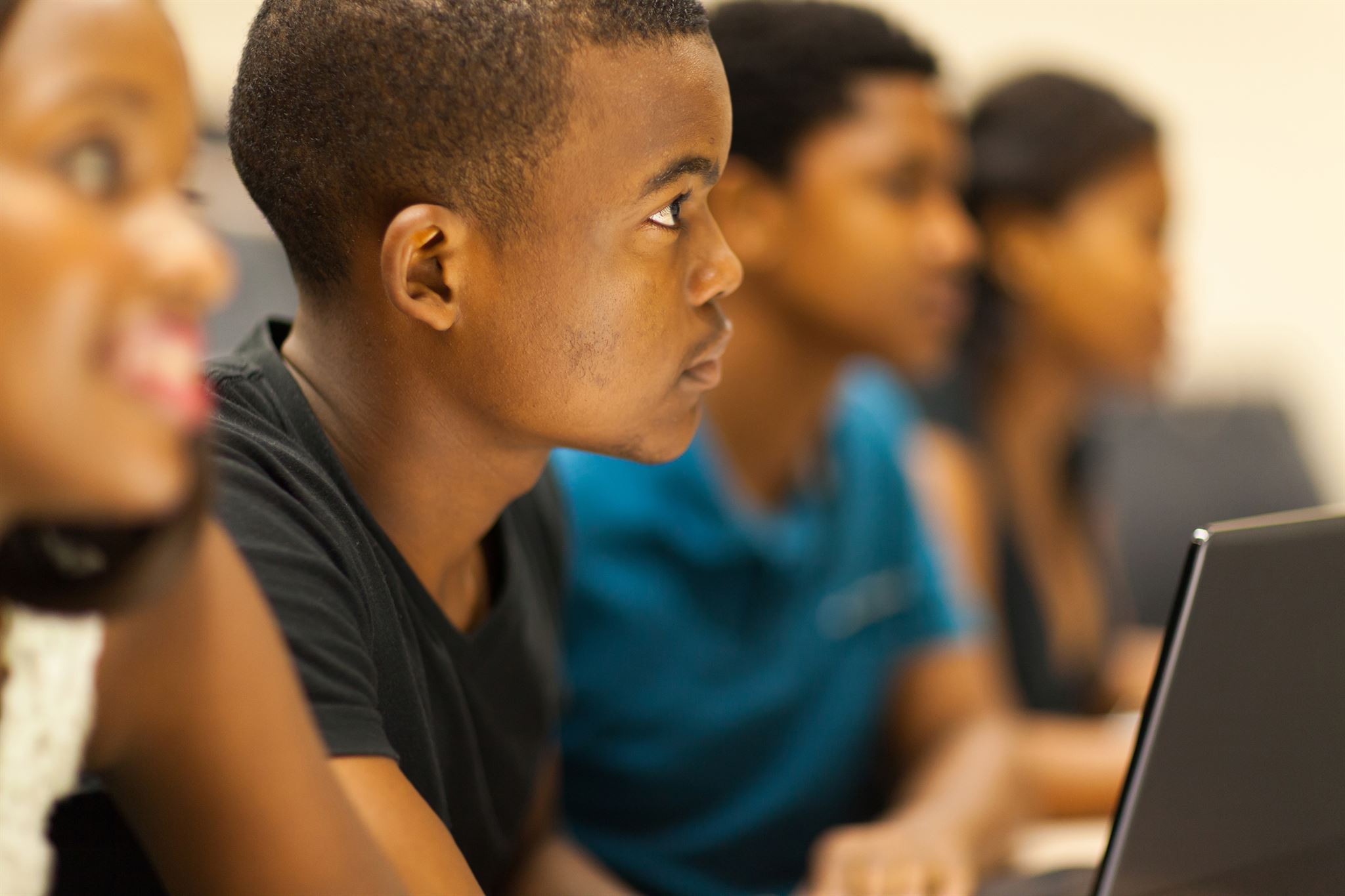 Four-students,-one-with-laptop,-in-lecture-room