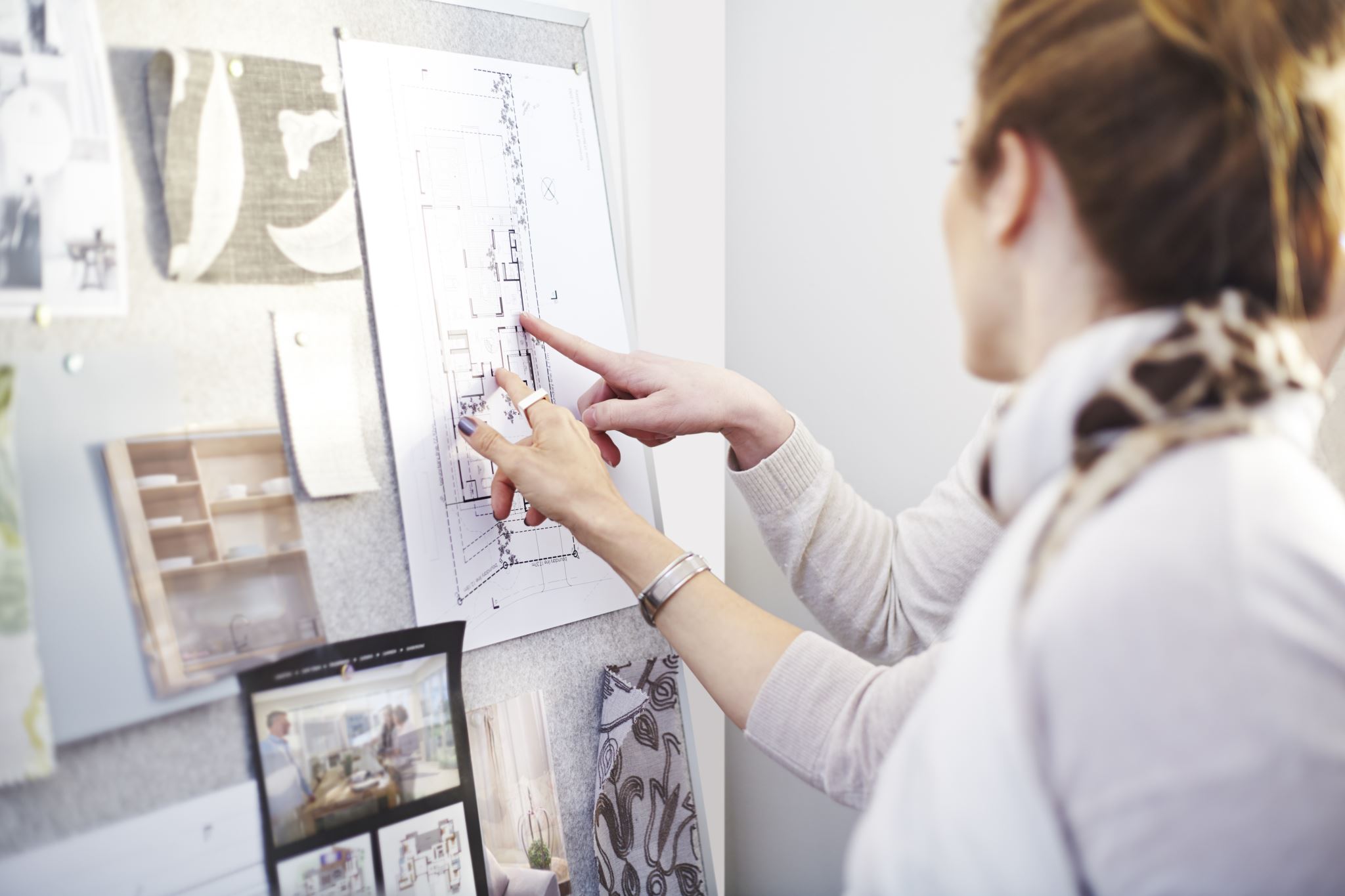 Interior-designers-discussing-blueprints-hanging-in-office
