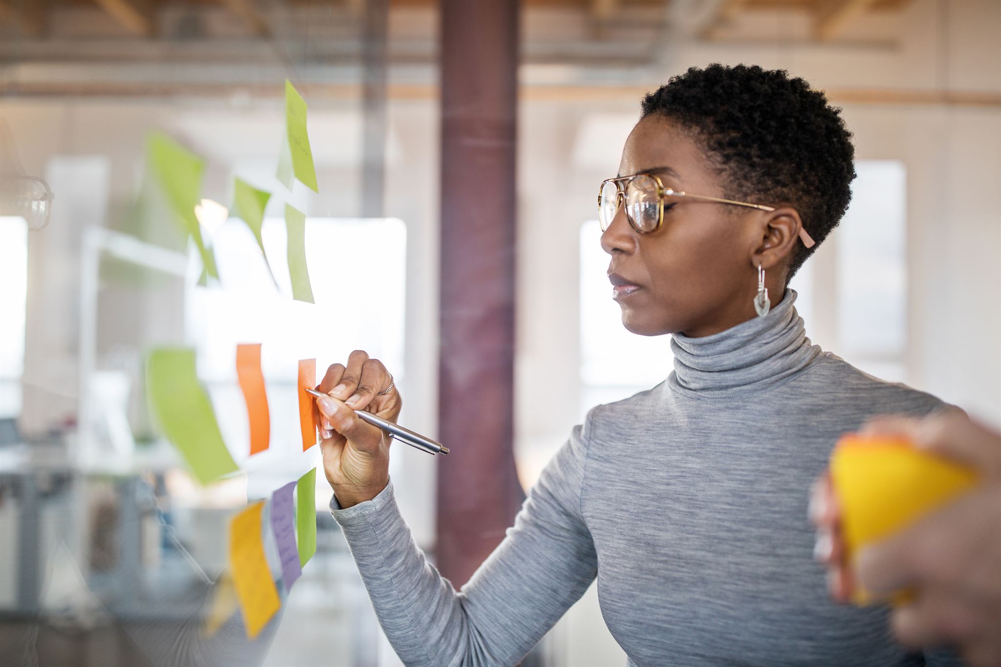 Woman-writing-on-sticky-note